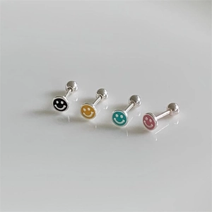 Detailed view of colorful enamel smiley face earrings in black, yellow, green and pink