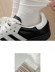 Detail of ribbed knit crew socks in white and brown with natural wood background