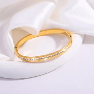 Macro shot of gold stainless steel bangle with inlaid diamonds and Roman numerals
