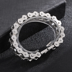 Close-up of a silver stainless steel biker chain bracelet on black textured background