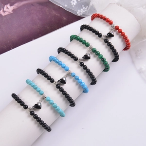 Close-up of magnetic heart-shaped charms and colorful beaded bracelets for couples
