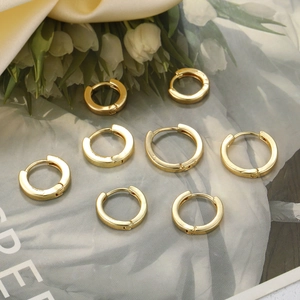 Set of 8 gold minimalist hoop earrings in various sizes on floral pattern and satin background
