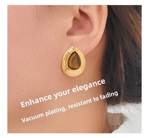 Macro shot of gold drop earrings with tiger eye stone and non-fade plating details
