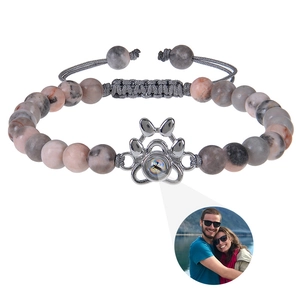 Detail of dog paw pendant with photo projection feature on natural stone bead bracelet