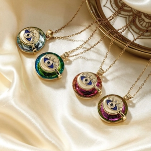 Minimalist gold evil eye pendant necklace with faceted crystal inlay on beige silk