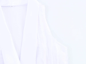 Close-up of white textured sleeveless dress showing suit collar and frayed edge details