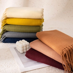 Dettaglio di morbide sciarpe effetto cashmere in vari colori con bordi a frange