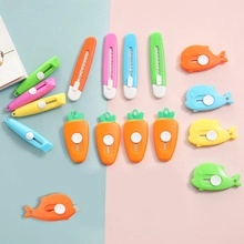 Flat lay of colorful cloud, carrot, and whale shaped mini utility knives for box opening