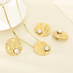 Flat lay of elegant gold hollowed butterfly jewelry set with pearls and snake chain