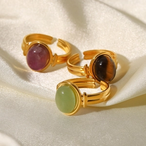 Vue détaillée de trois bagues dorées 18K avec pierres violettes, vertes et œil de tigre