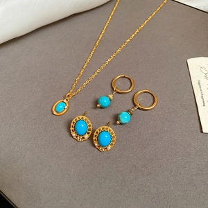 Flat lay of vintage gold jewelry set with turquoise stones and happiness label