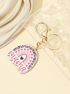 Detail of mama leopard print rainbow keychain with golden metal ring on beige background
