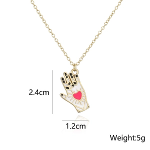 Close-up of palm-shaped pendant with white enamel and red heart showing dimensions
