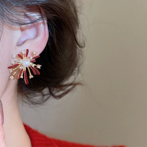 Macro shot of radial firework stud earring with red enamel and white crystals