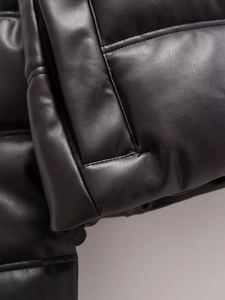 Détail d'une veste en cuir noir de qualité avec coutures précises et zip invisible