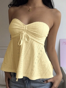 Detailed view of pale yellow eyelet tube top with drawstring ruching and embroidery