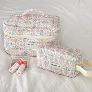 Set of two quilted floral cosmetic bags in blue and pink with convenient handles