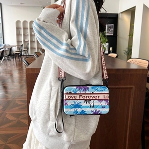 Détail du sac bandoulière matelassé bleu clair avec palmier et sangle Love Forever