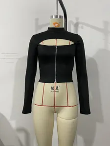 Détail du haut moulant noir à col montant avec découpe frontale et fermeture éclair