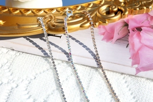 Close-up of sparkling rhinestone necklaces in silver and gold on vintage frames