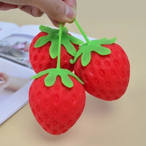 Three realistic red strawberry stress relief toys with soft texture and green leaves