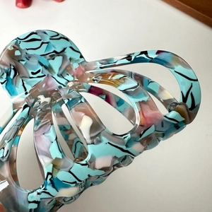 Blue acetate hair claw clip with colorful marble pattern and tortoiseshell texture finish