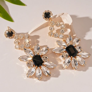 Macro shot of sparkling gold flower earrings with crystals on a stone background