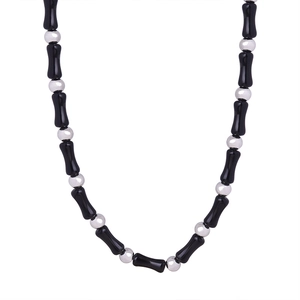 Handmade necklace featuring black natural onyx stones and silver round beads on white background