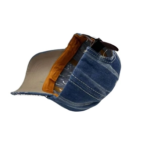 Detail of denim baseball cap interior with orange webbing and adjustable leather strap