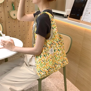 Dettaglio della borsa tote in tela gialla con motivo floreale di tulipani rossi