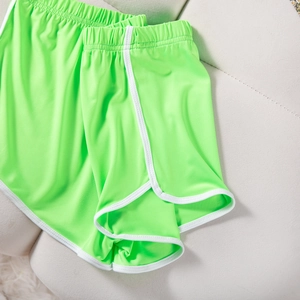 Detail of neon green sports shorts featuring white trim and elastic waistband texture