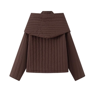 Detail of deep brown quilted jacket featuring a wide shawl collar and stitched texture