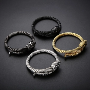 Detail view of four twisted steel cable snake bracelets in gold, silver, black, and gunmetal