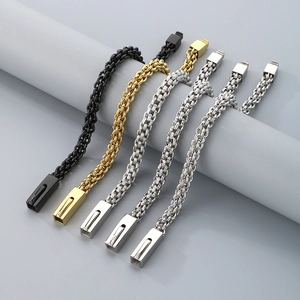 Three-color woven stainless steel bracelets on gray cylindrical props showing flexible chains
