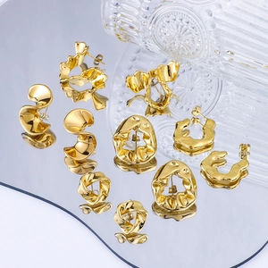 Irregular geometric gold pleated stud earrings in stainless steel on reflective mirror surface