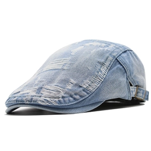 Dettaglio del berretto in denim azzurro con strappi vintage e fibbia in metallo laterale