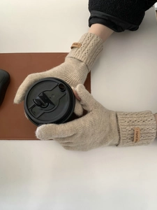 Détail de gants d'hiver en tricot beige doux avec une étiquette de style cuir Hand Made élégante
