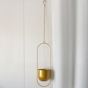 Close-up of minimalist golden metal hanging planter with chain and S-hook for indoor plants