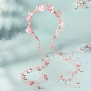 Detail of pink floral headband with pearls and dangling beaded fringe tassels