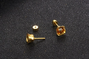 Detailed view of gold flower earrings with zircon center and secure screw backs