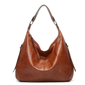 Detail of vintage brown PU leather hobo bag showing texture and metal ring buckle