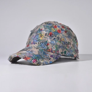 Close-up of distressed baseball cap with colorful floral prints and frayed edge details