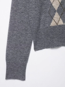 Close-up of the grey argyle knit pattern and fine stitching on a wool blend sweater