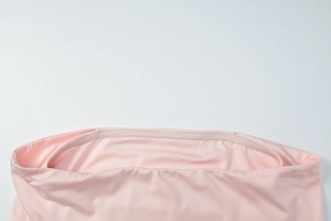 Close-up of the reinforced stitching on the pink elastic waistband of yoga leggings