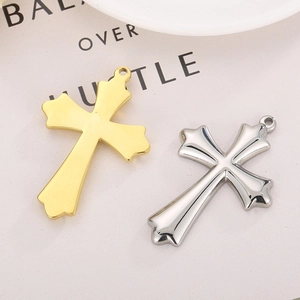 Pendentifs en forme de croix polis en or et argent vus sous un angle de 45 degrés