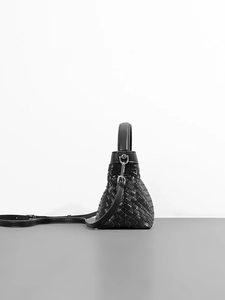 Elegant black woven leather crossbody Kelly bag with silver hardware and trapezoid silhouette