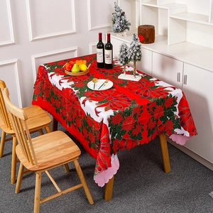 Nappe de Noël rouge avec imprimés fleurs et nœuds sur une table décorée