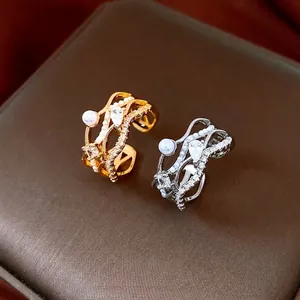 Bagues dorées et argentées multicouches avec perles et zircons sur boîte à bijoux