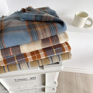Detail of soft plaid scarf showing thick cashmere-like texture and fringed edges