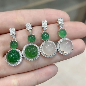 Close-up of green and icy white chalcedony pendants with sparkling zircon borders